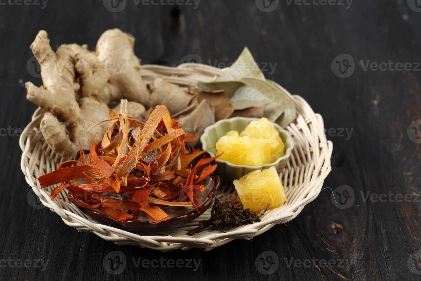 ingredientes wedang uwuh, bebida tradicional de ervas de yogyakarta, indonésia. é feito de folhas de cravo, noz-moscada, canela, gengibre, kayu secan e açúcar de rocha. foto