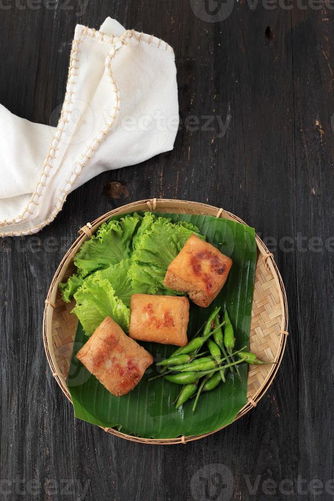 vista superior tahu bacem, tofu cozido doce e salgado com molho de soja doce. servido com pimenta verde foto