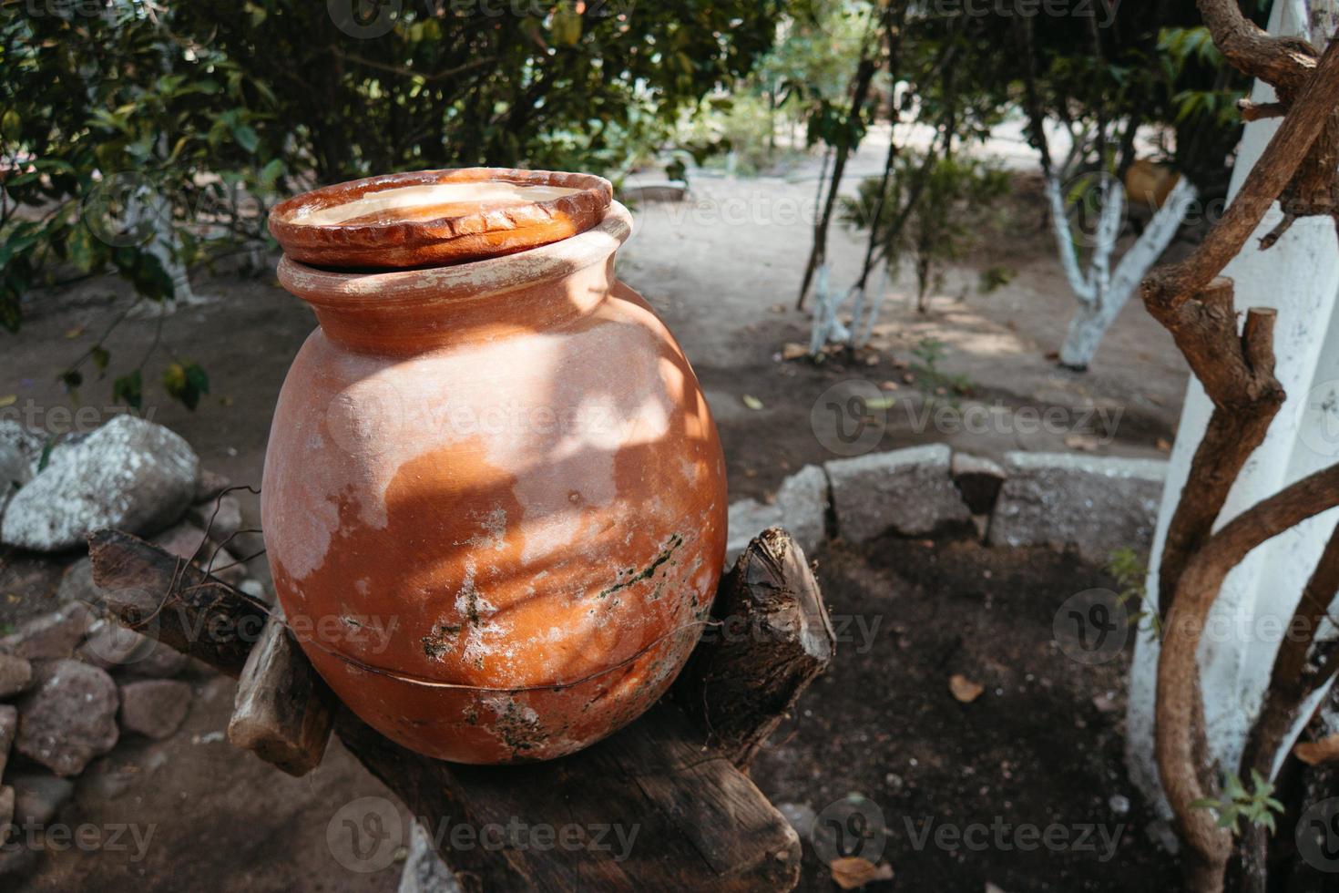 jarro de água de barro. jarro de barro feito à mão isolado. jarro tradicional. pote de cerâmica antigo foto