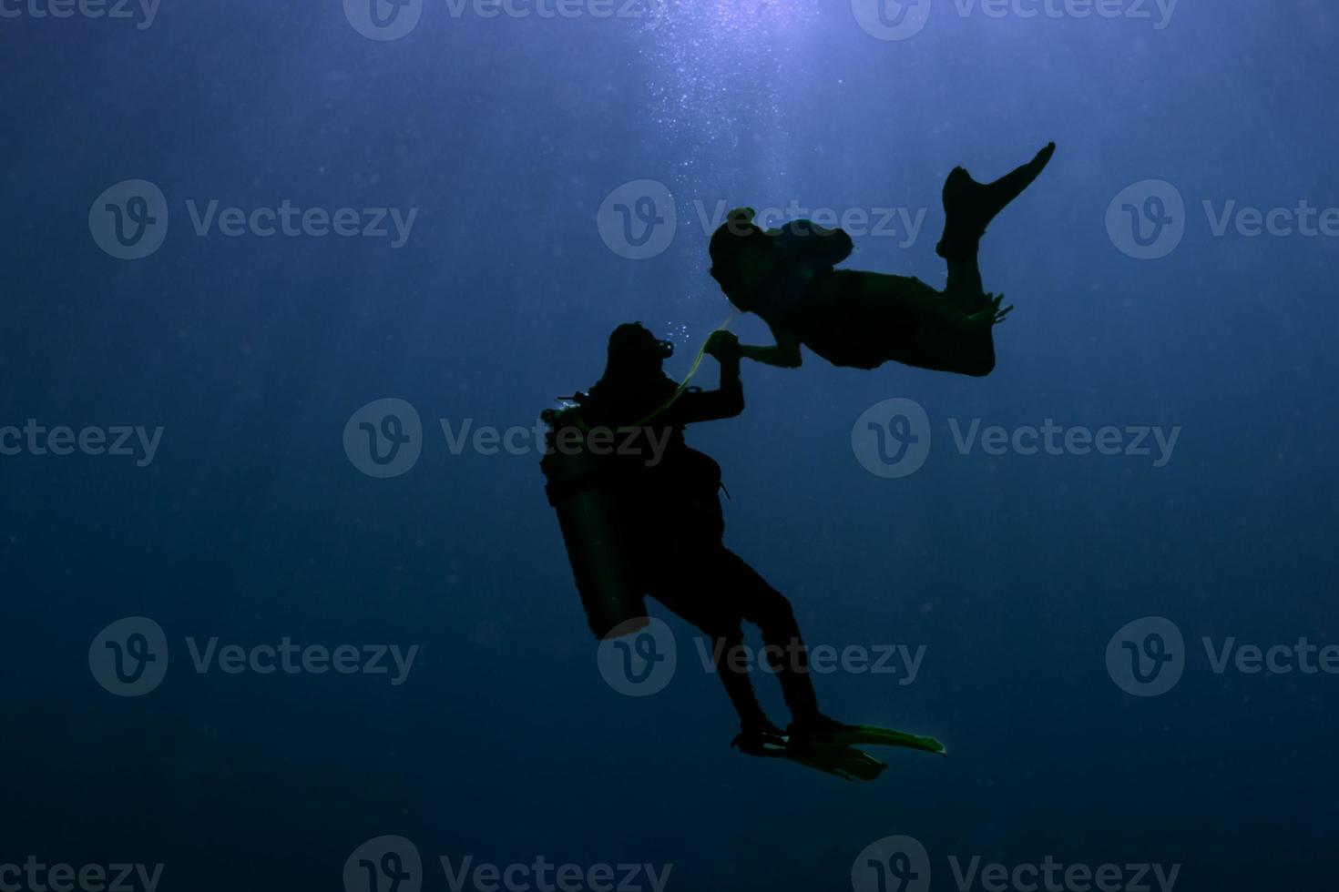 silhueta de sereia sereia ao conhecer um mergulhador debaixo d'água foto