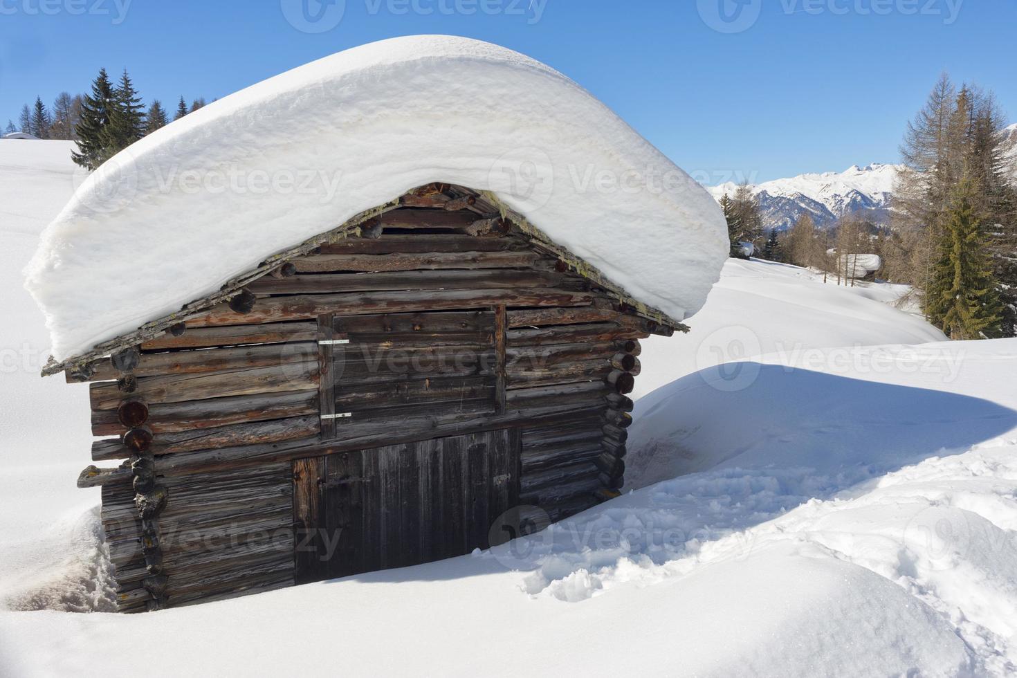 uma cabana de madeira no fundo da neve do inverno foto