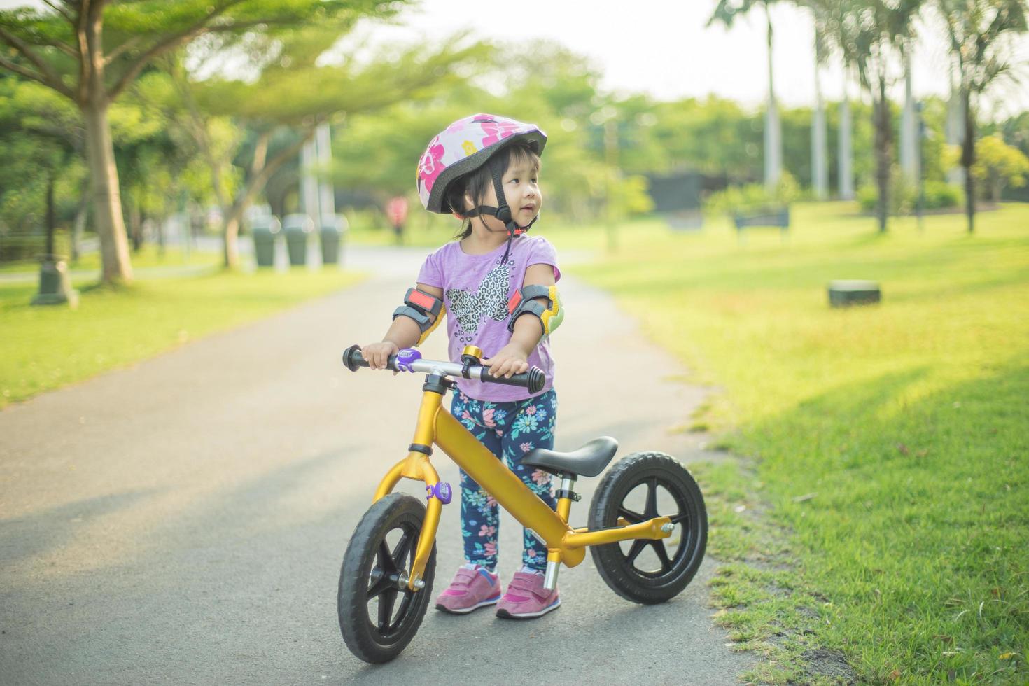 menina aprende bicicleta fora na ciclovia foto