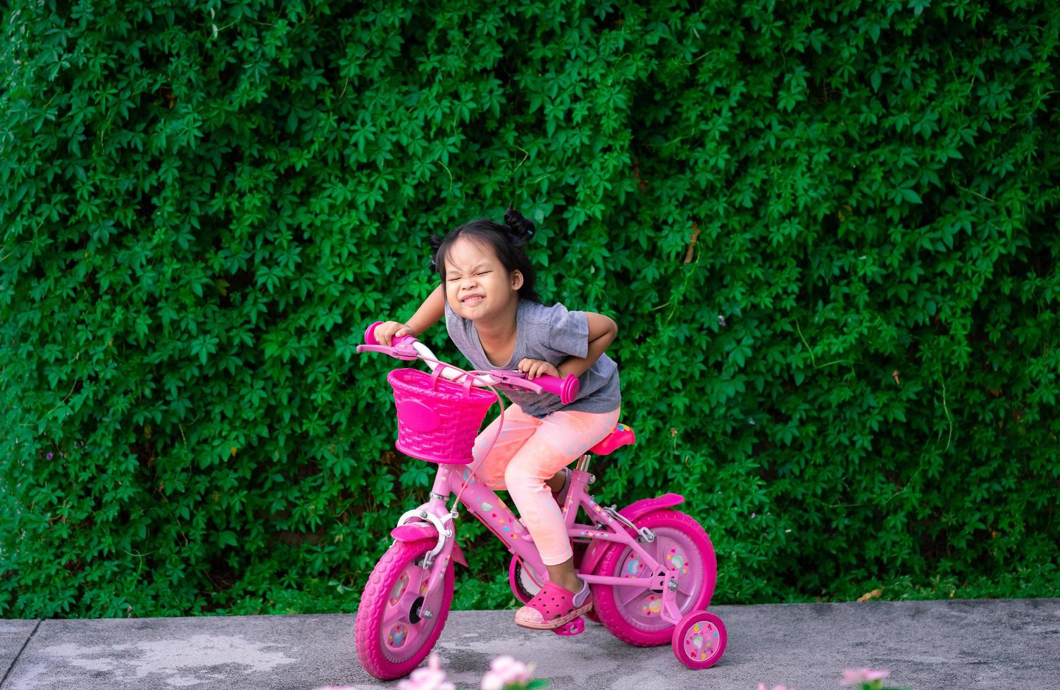 jovem menina asiática andando de bicicleta foto