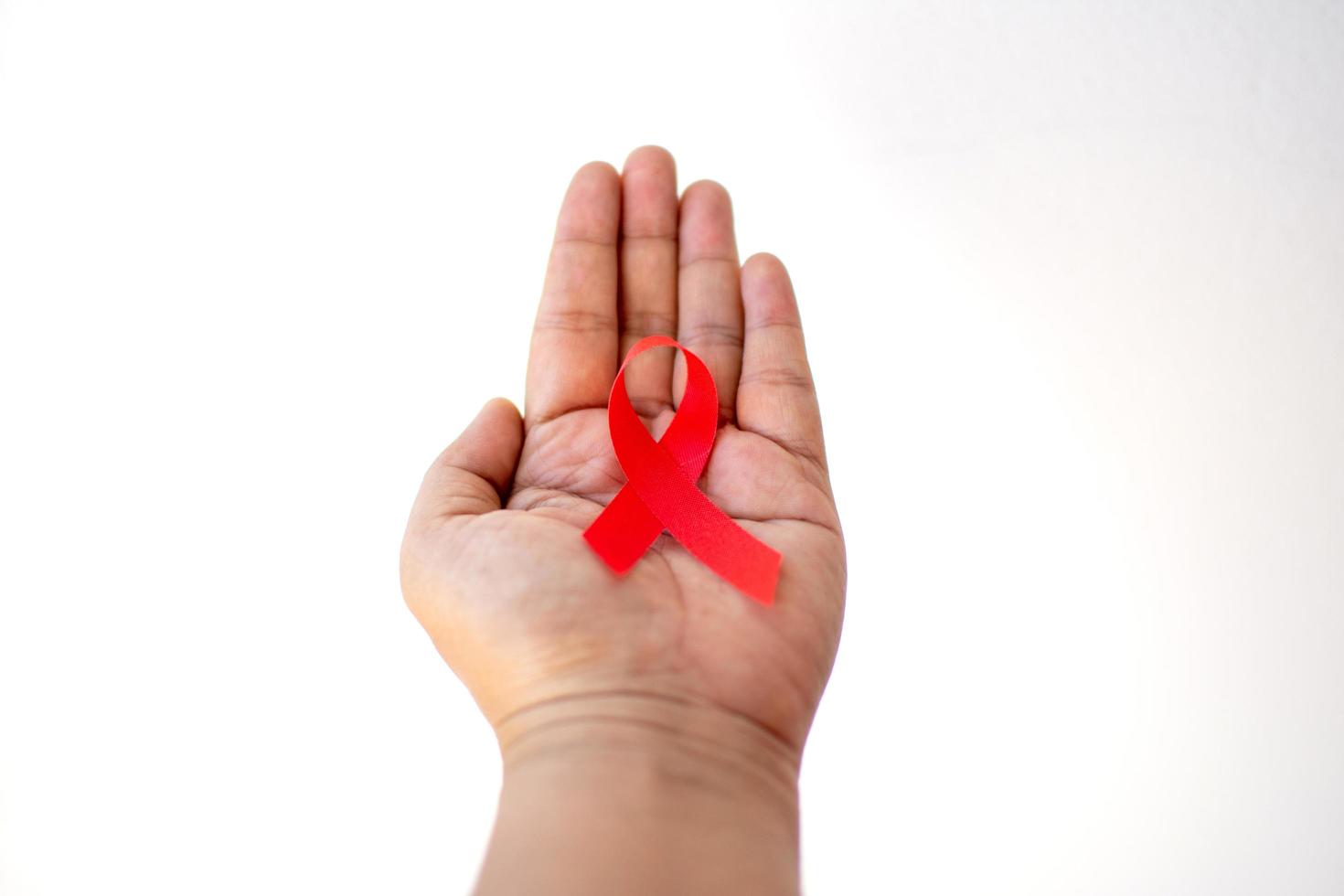 fita vermelha na mão para o dia mundial da Aids foto