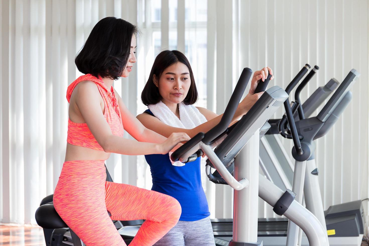 duas mulheres exercitando na academia foto