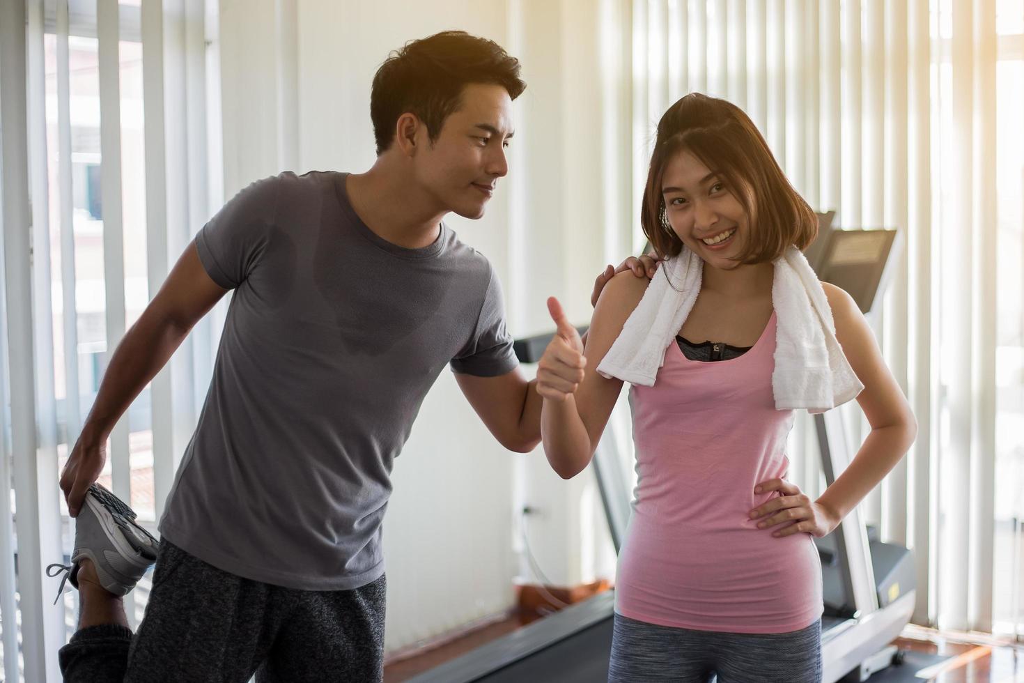 dois adultos exercitando na academia foto