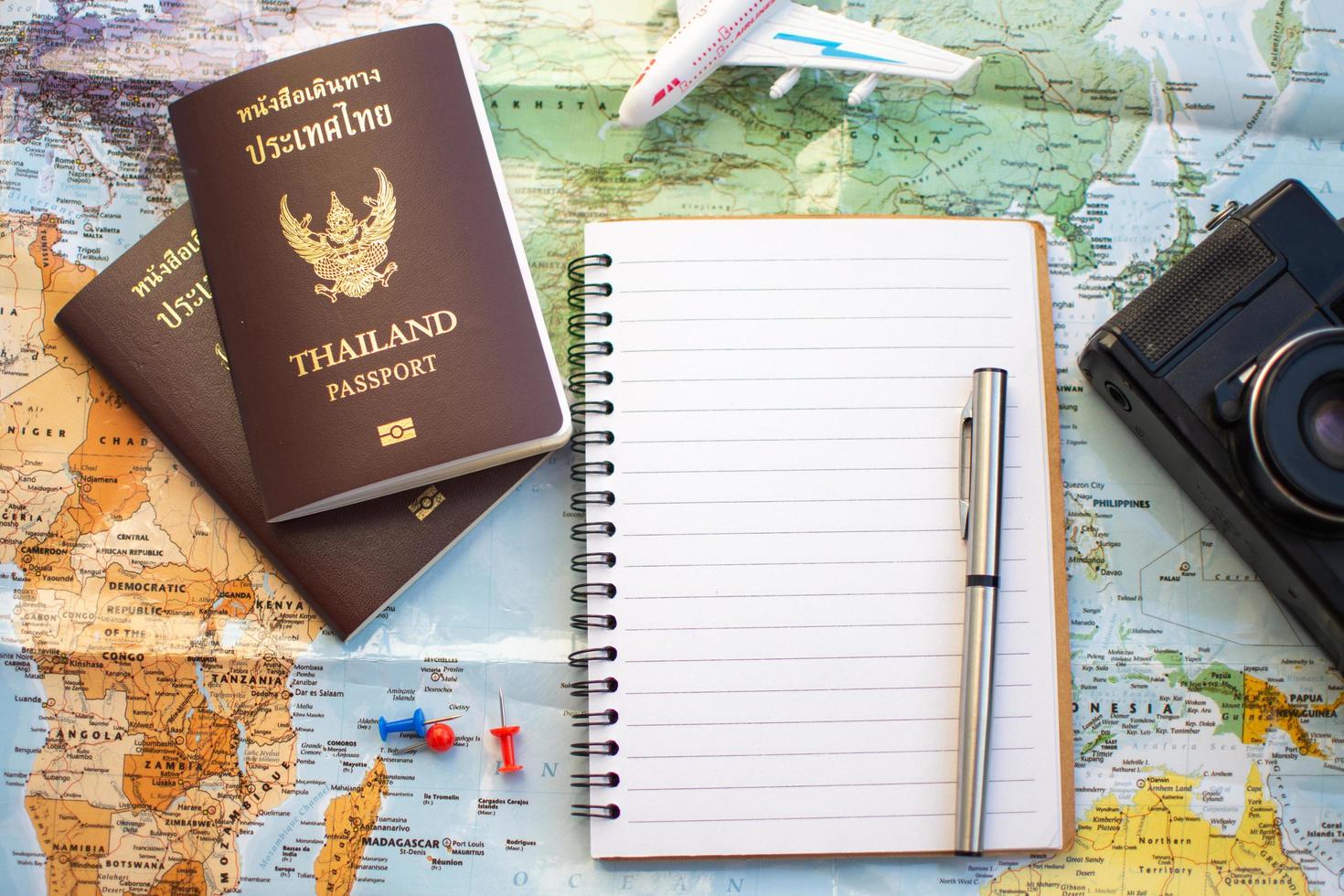 caderno com passaporte ao lado do mapa foto