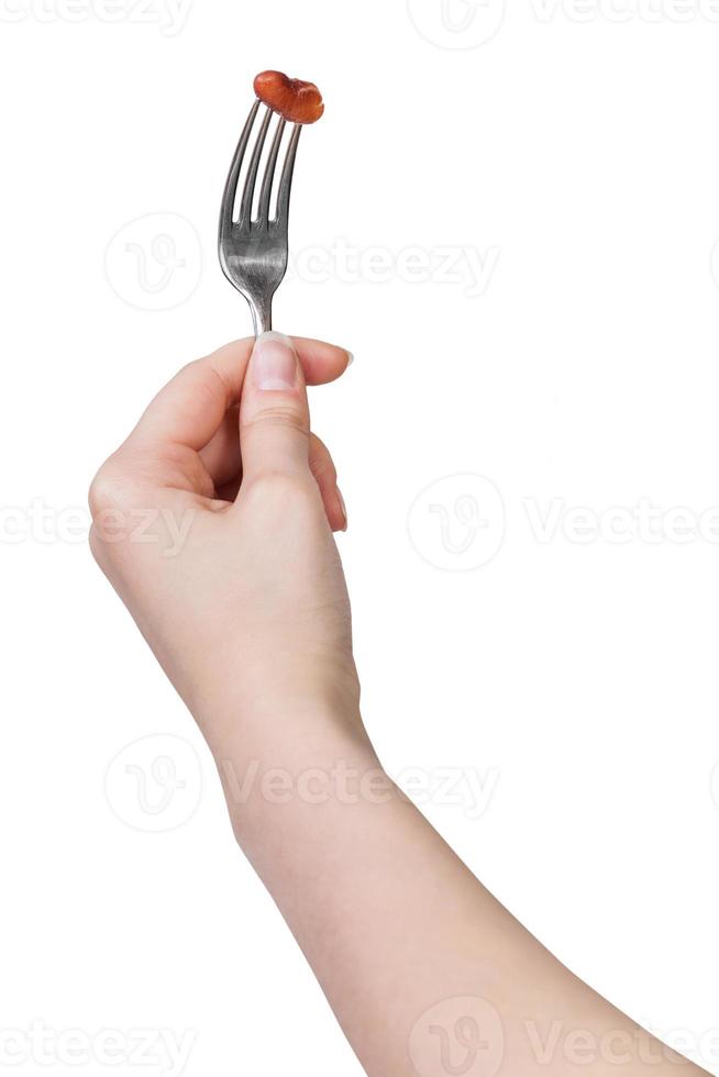 mão segurando o garfo de jantar com feijão marrom empalado foto