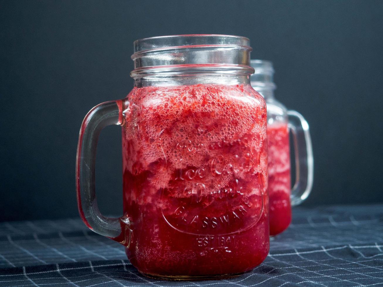 close-up de suco de cranberry beber em potes de vidro foto