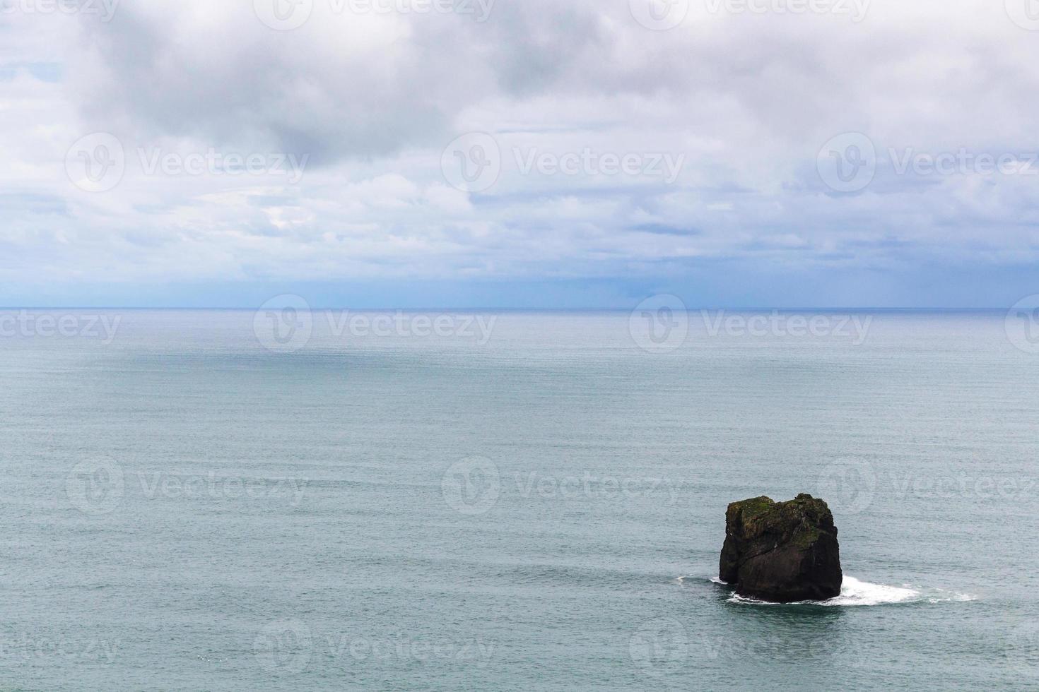 pedra no oceano atlântico perto do promontório de dyrholaey foto