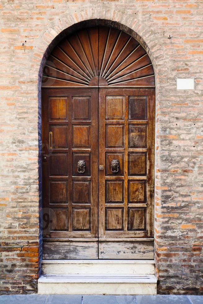 porta de madeira na parede de tijolos da casa medieval foto