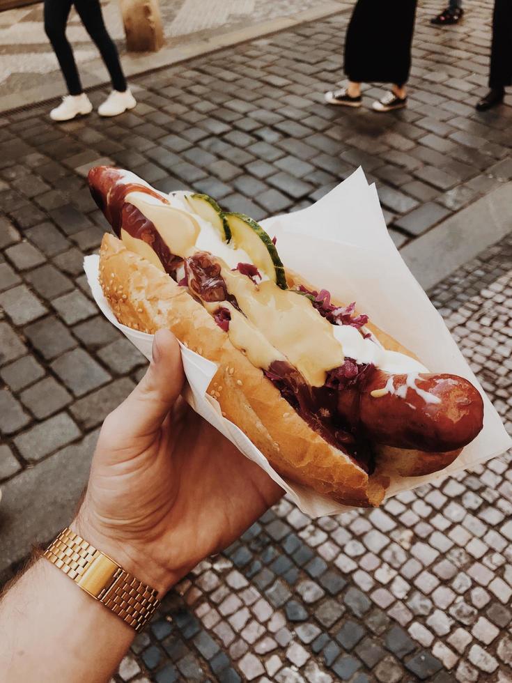 mão segurando footlong cachorro-quente foto