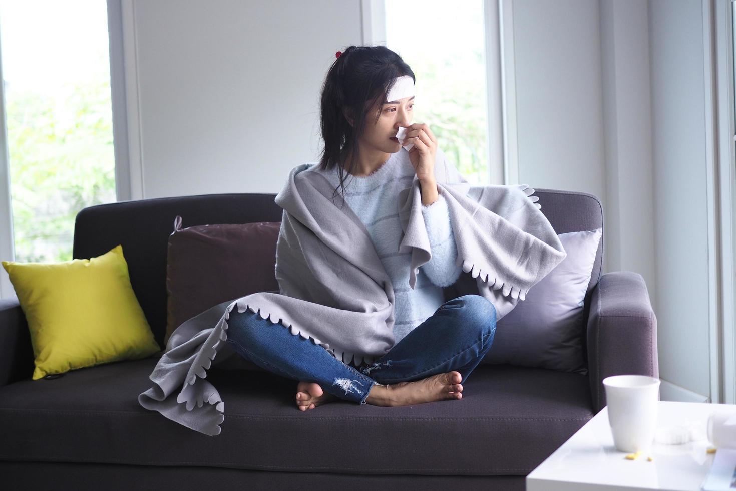 mulheres asiáticas doentes em casa no sofá foto