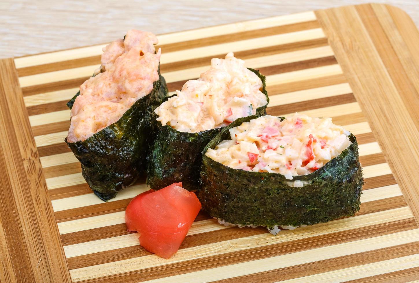 sushi gunkan na placa de madeira e fundo de madeira foto