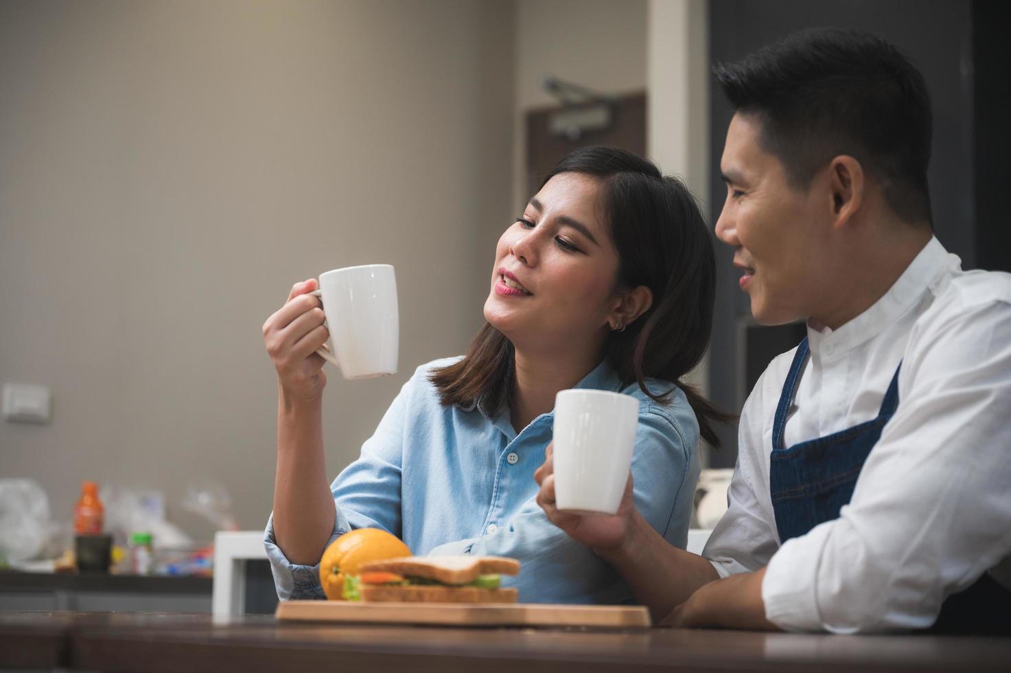 casal na cozinha sente-se sobre o café foto