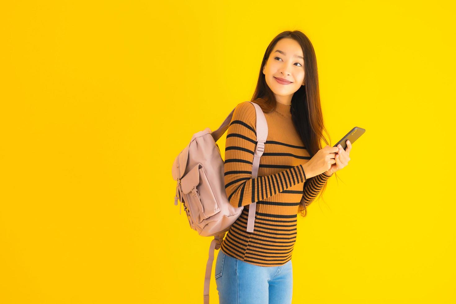 mulher asiática com mochila e smartphone foto