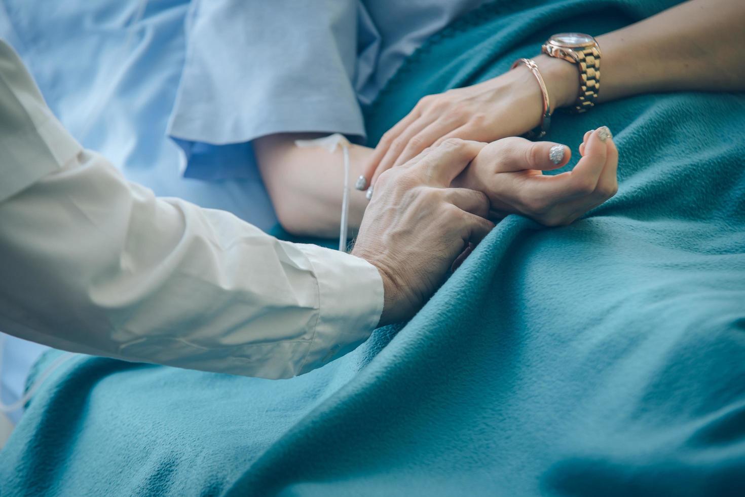 médico, verificando o pulso do paciente foto