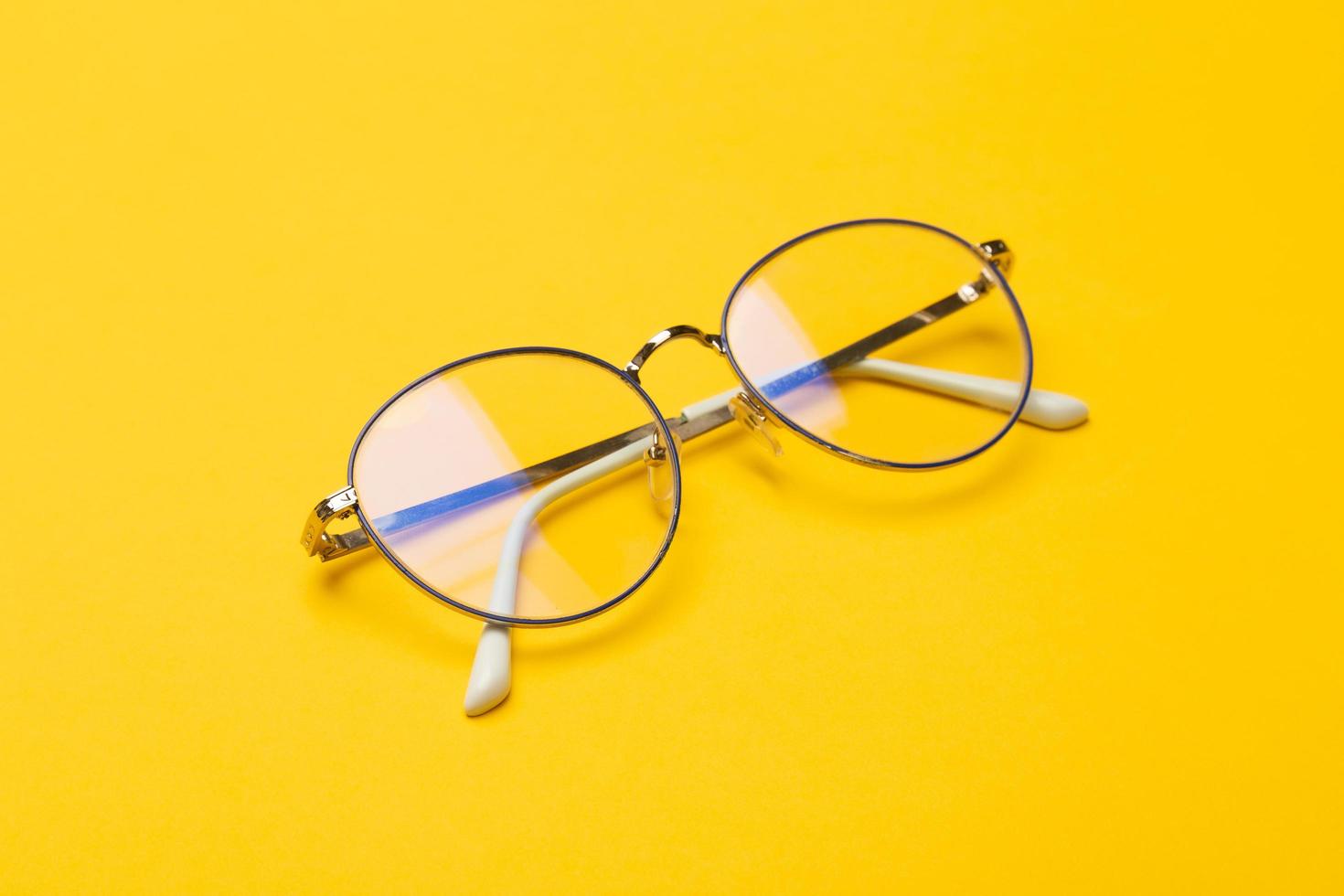par de óculos em fundo amarelo foto