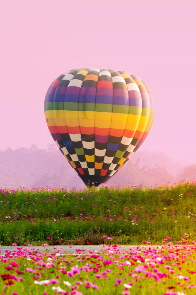 balão de ar quente colorido pousando no campo foto