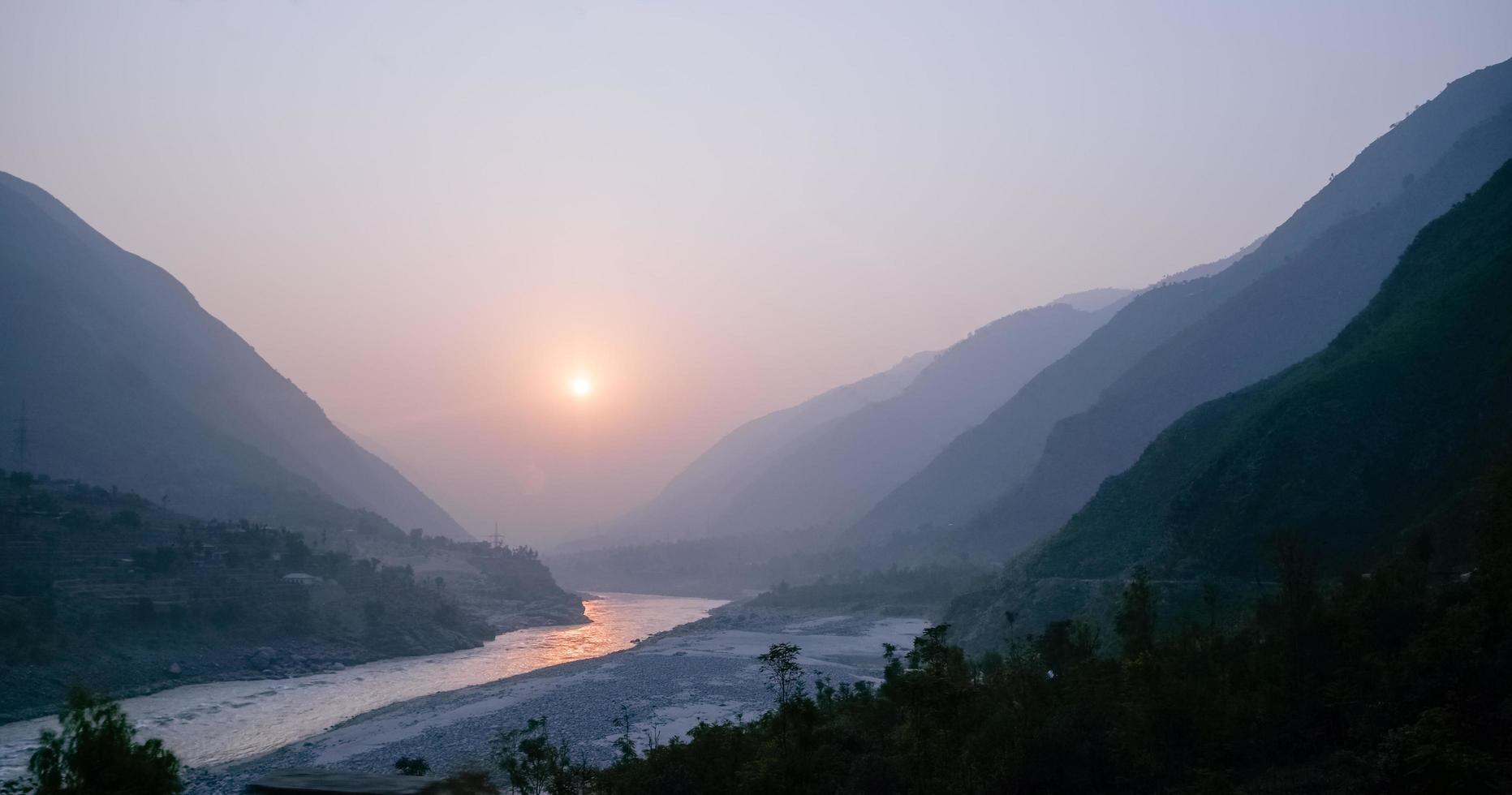 pôr do sol nevoento sobre o rio indus foto