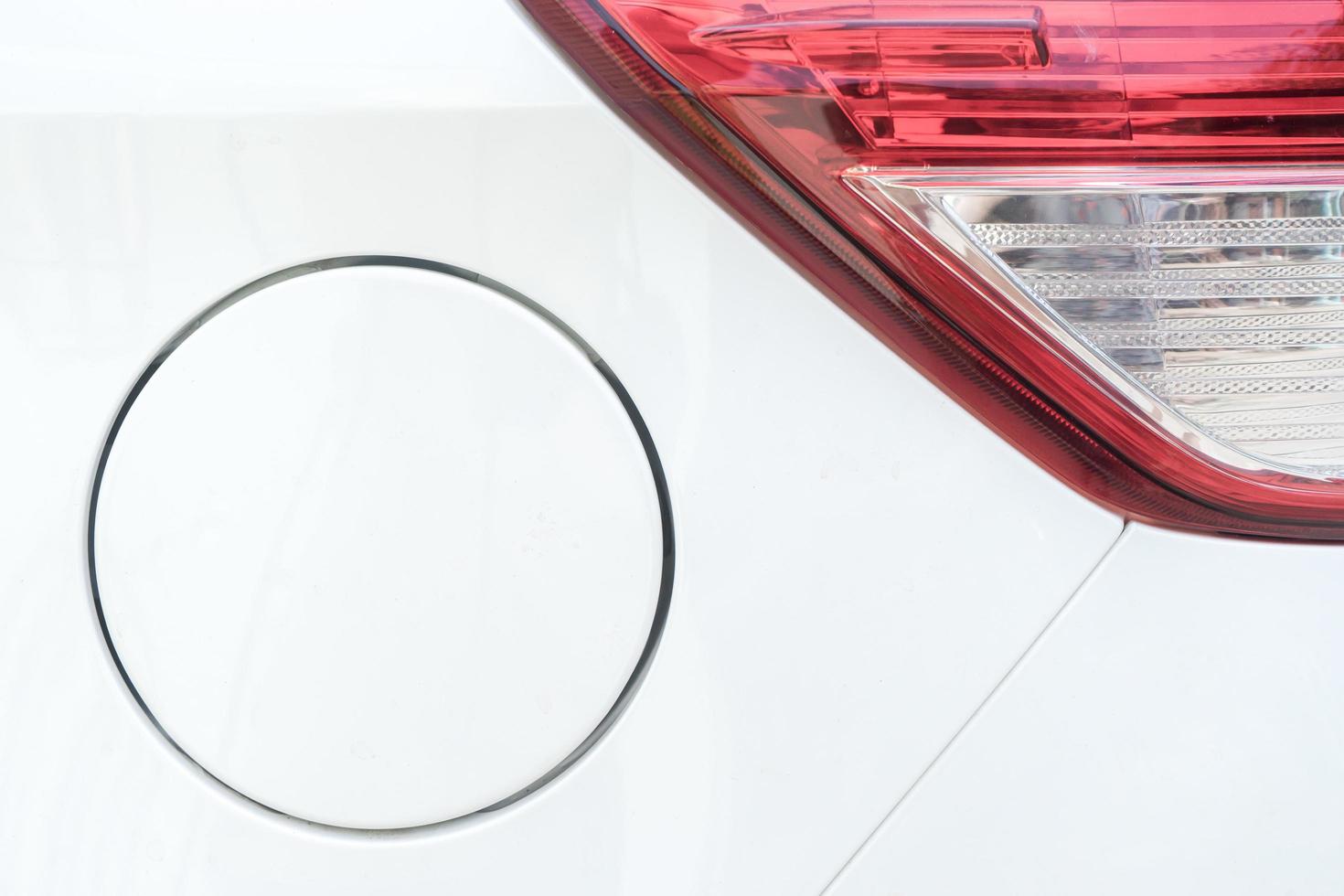 close-up de luz traseira e tampa de gás no carro branco foto
