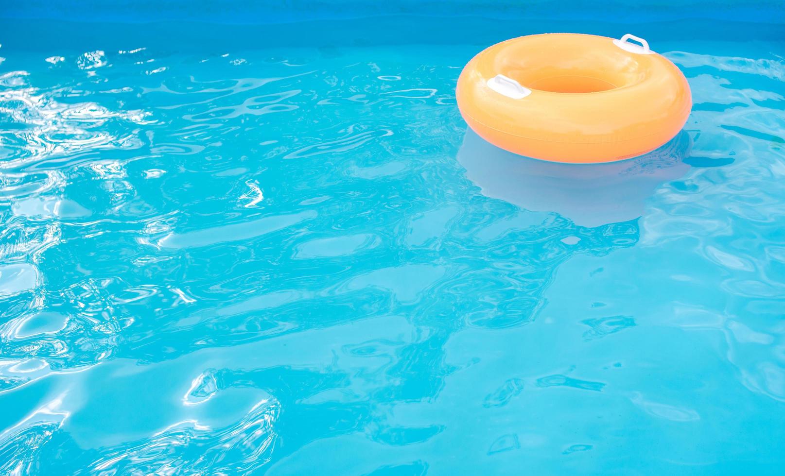 tubo inflável laranja na piscina. foto