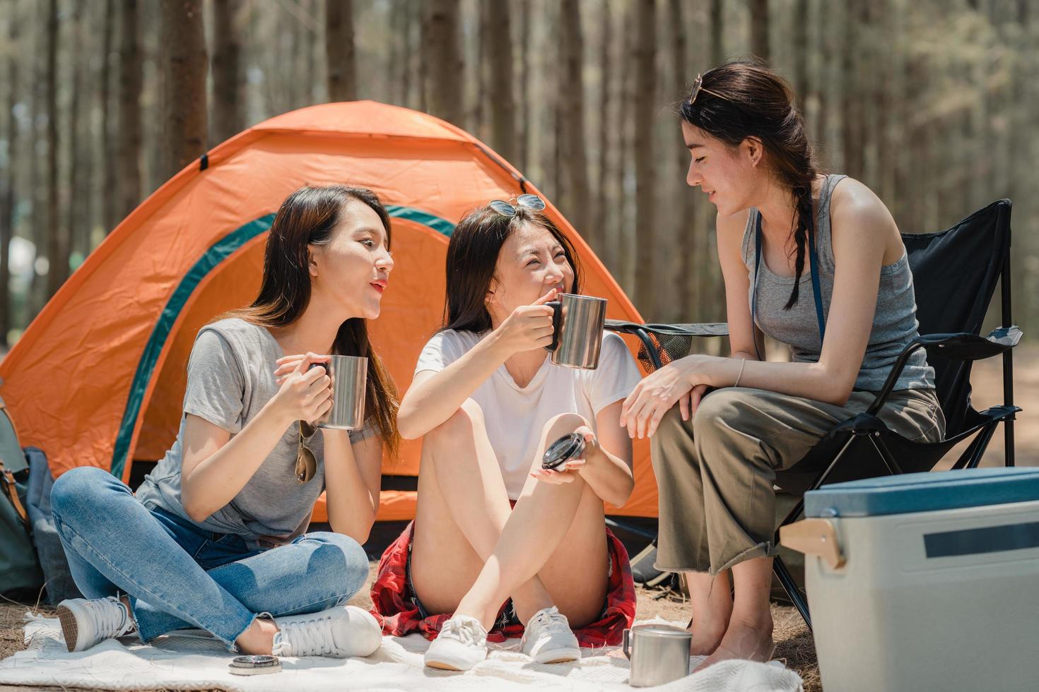 grupo de jovens amigos asiáticos acampar juntos em uma floresta. foto