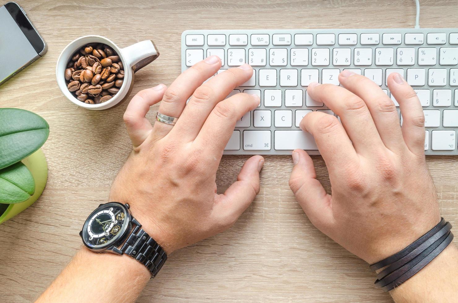 homem escrevendo em um teclado foto