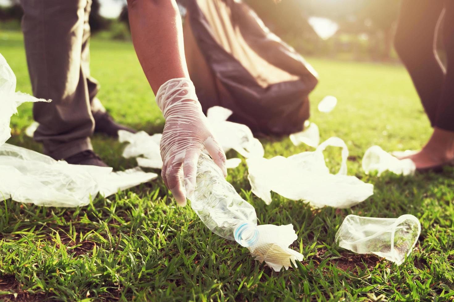 voluntários catando lixo em um parque foto