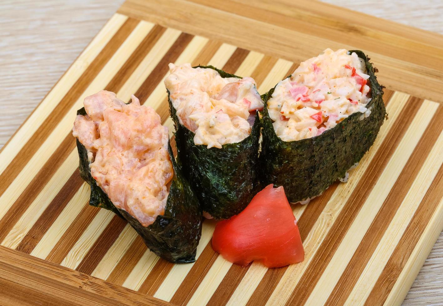 sushi gunkan na placa de madeira e fundo de madeira foto