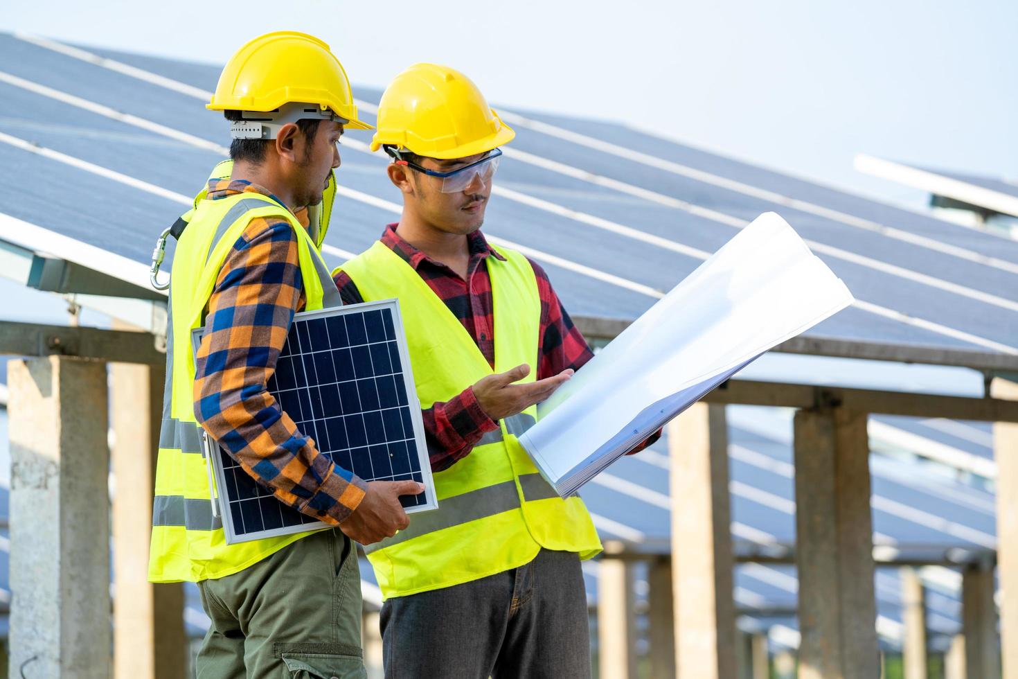 homens usando equipamentos de segurança ao lado de painéis solares foto