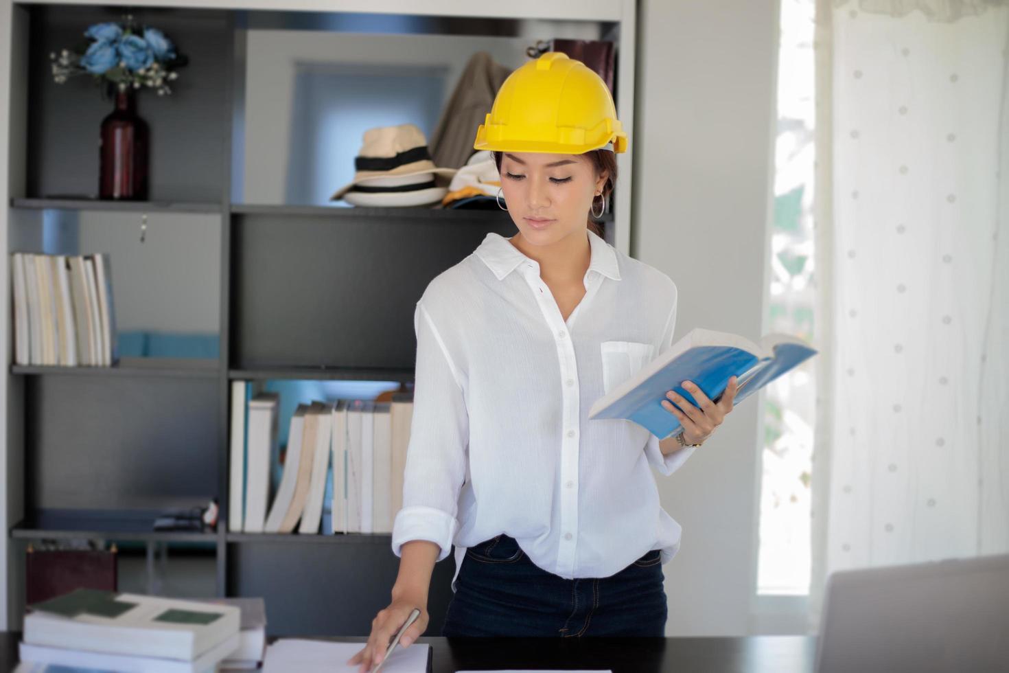 mulher asiática com capacete no escritório foto