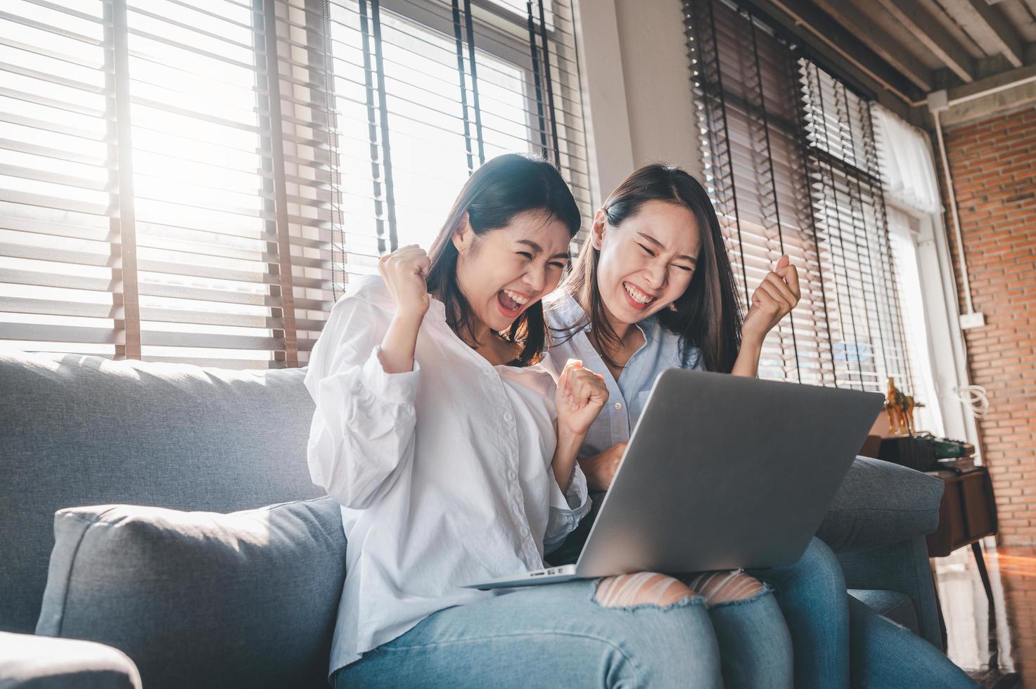 melhores amigas asiáticas excitadas enquanto estiver usando o laptop em casa foto