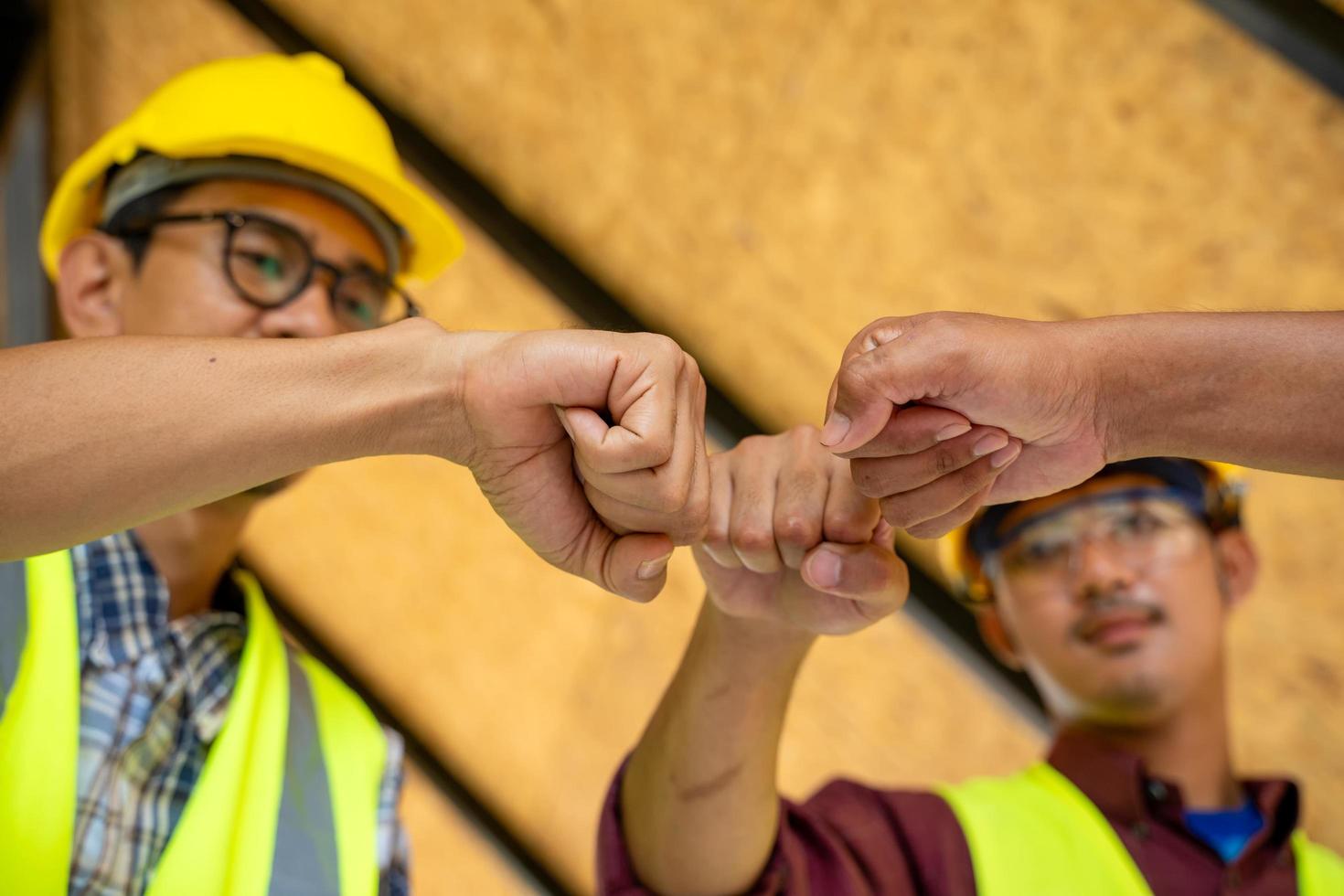 três homens colocando os punhos juntos foto