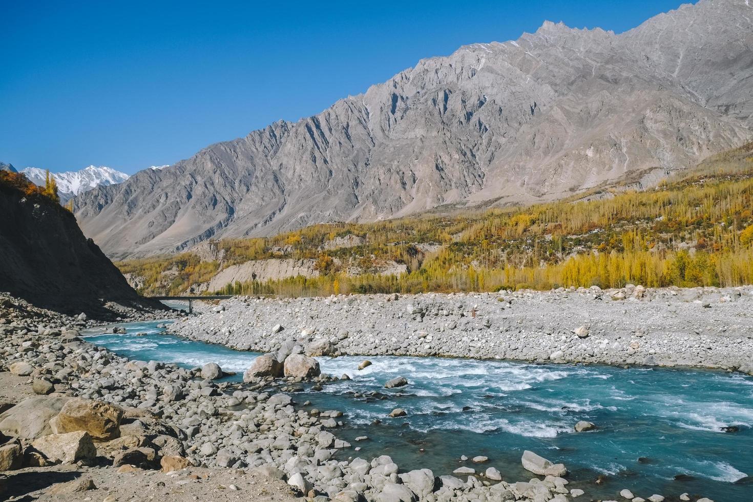 rio hunza que flui através da montanha karakoram no outono foto