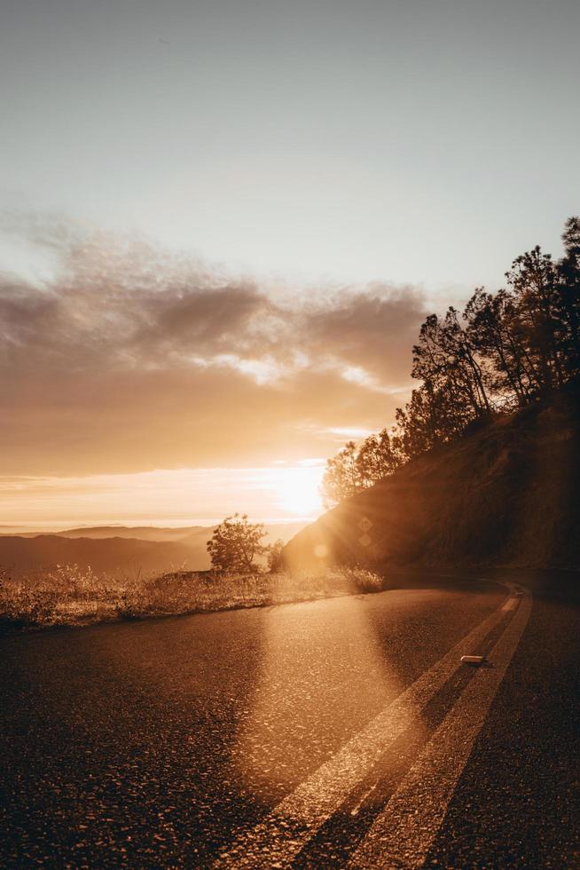 estrada sinuosa através das colinas ao nascer do sol foto