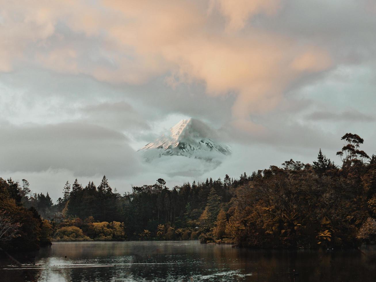 pico de montanha nevado coberto por nuvens foto