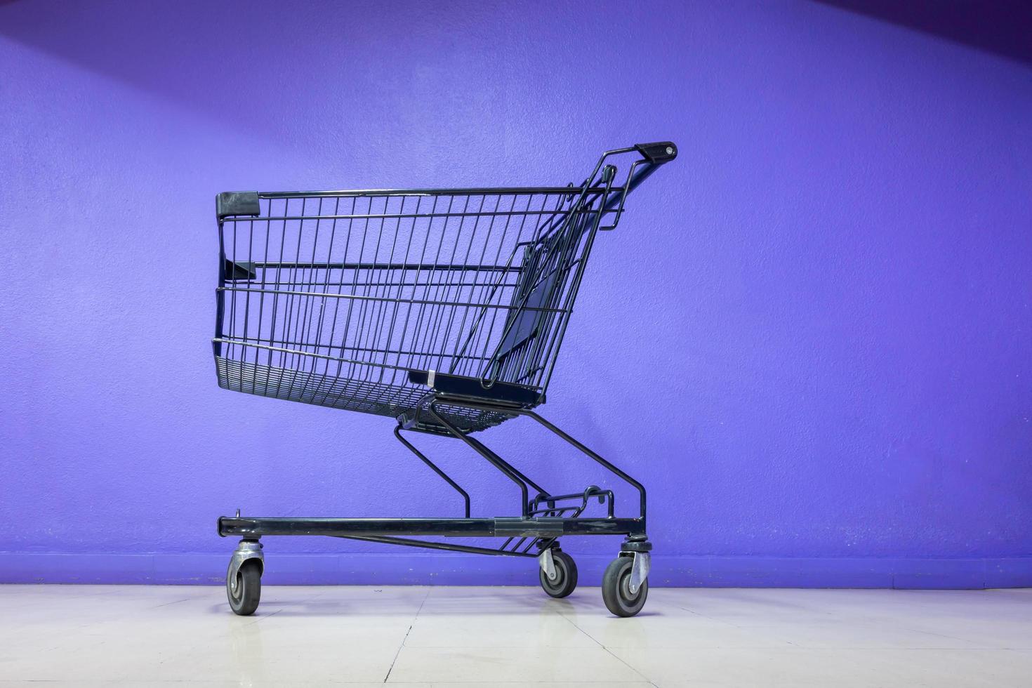 carrinho de compras em frente a parede roxa foto