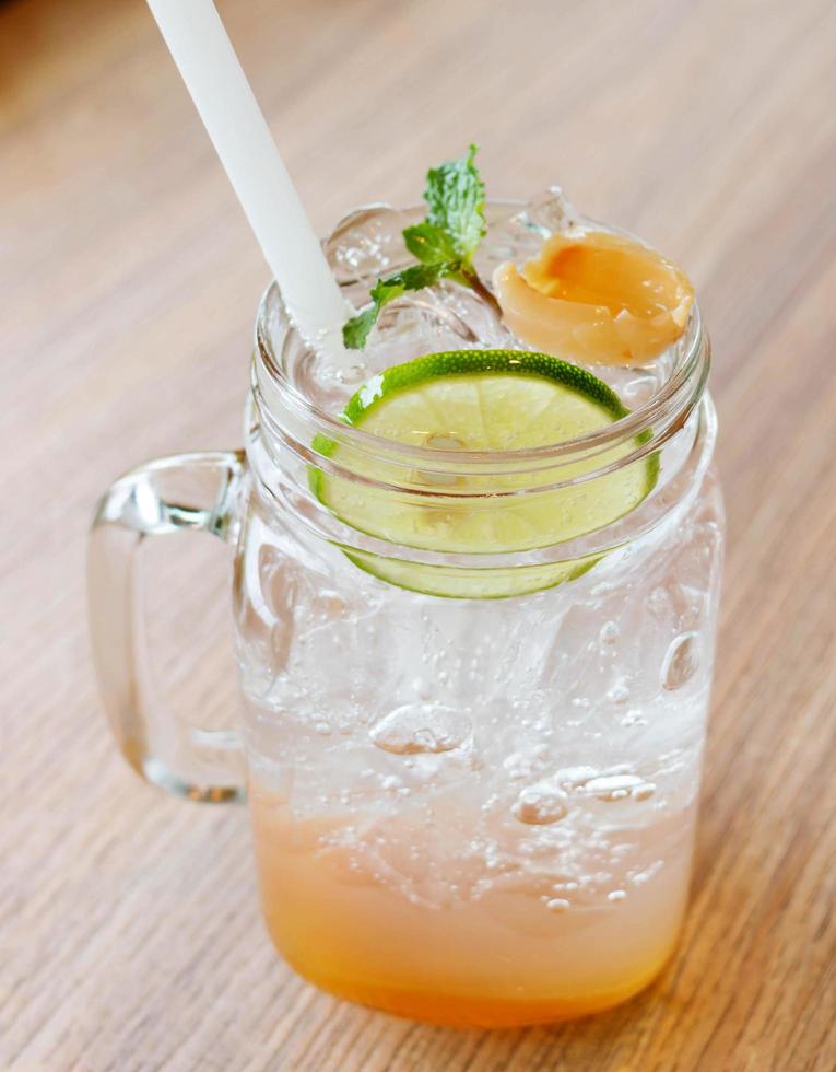 copo de limonada gelada na mesa de madeira foto