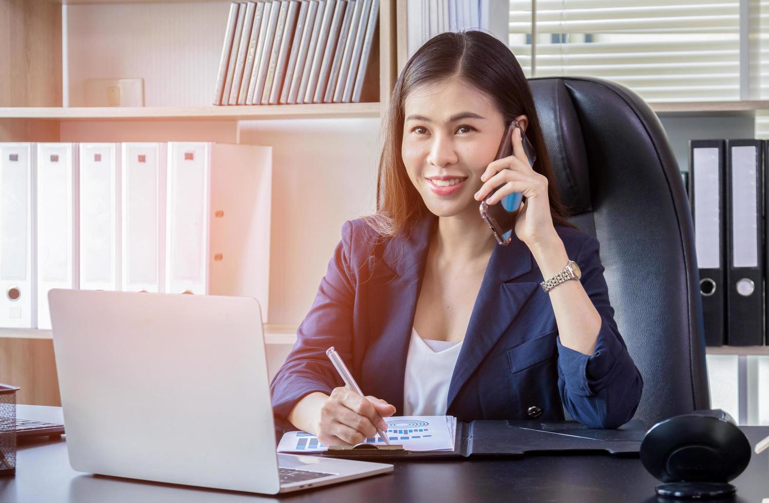 jovem mulher asiática usando smartphone no trabalho foto