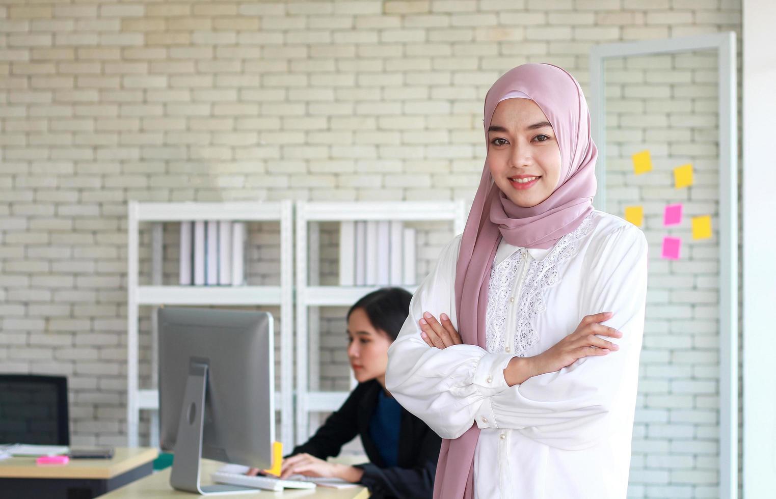 mulher muçulmana e amigo no escritório moderno foto