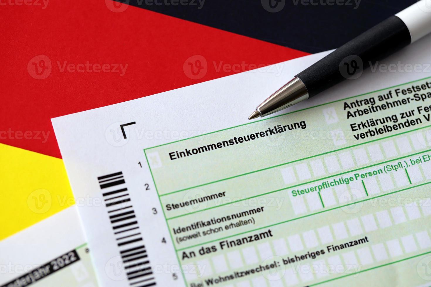formulário de declaração de imposto de renda anual alemão com caneta na bandeira close-up. o conceito de relatórios fiscais na alemanha foto
