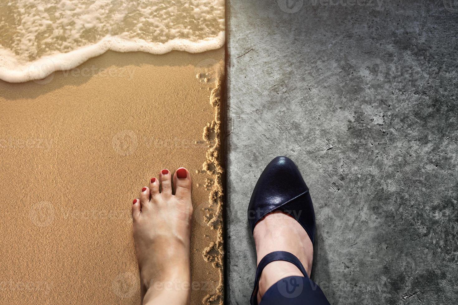 conceito de equilíbrio de vida para trabalho e viagens presente na posição de vista superior por metade dos sapatos de mulher que trabalha no chão de cimento e descalço da mulher na praia de areia foto