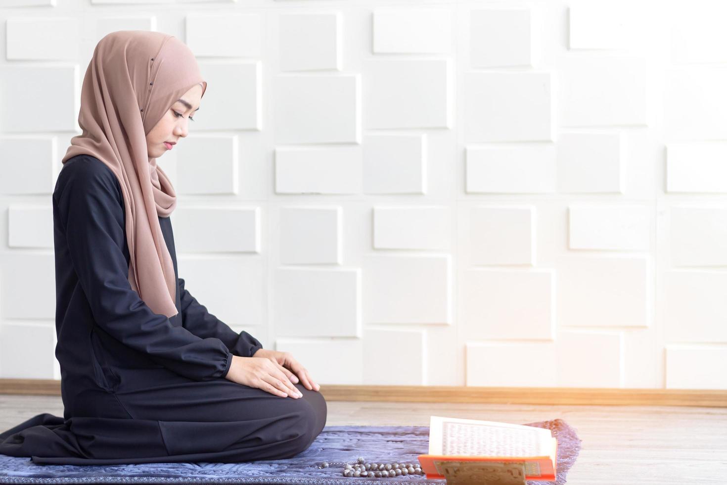 mulheres muçulmanas vestidas de hijab preto, orando foto