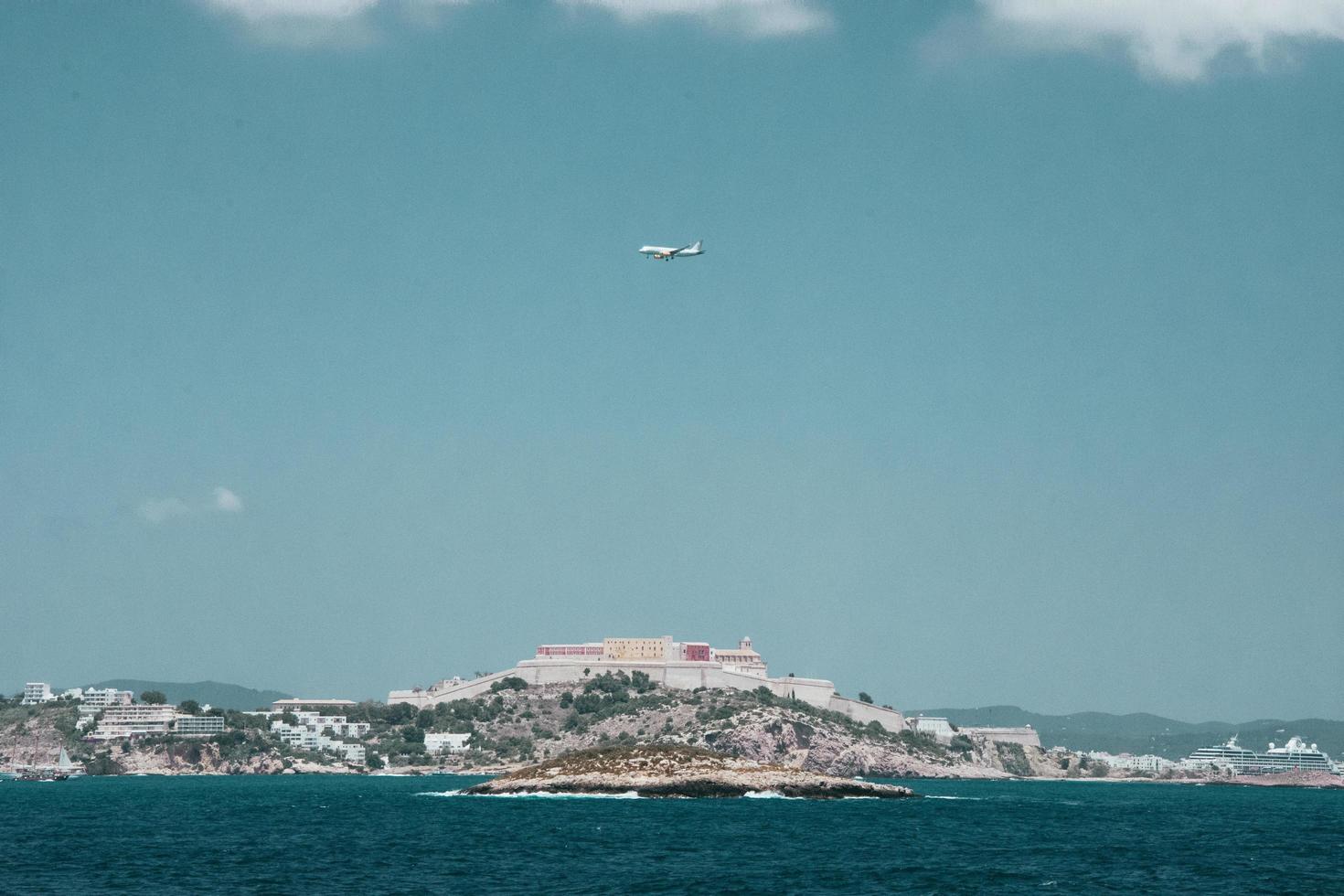 avião branco sobrevoando uma cidade foto