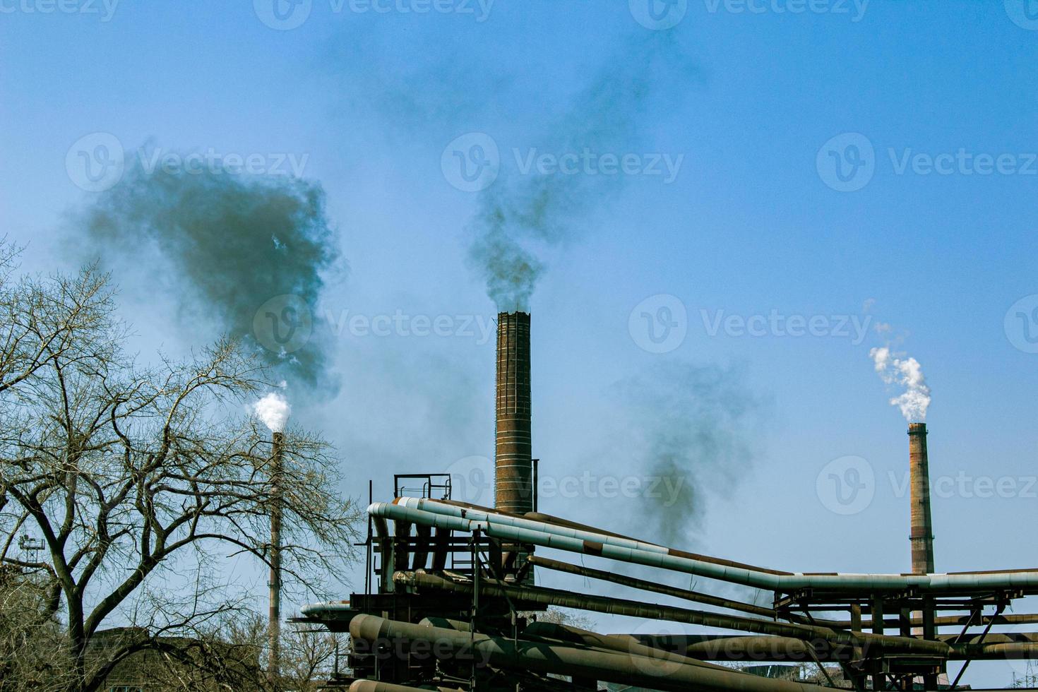 fumaça da chaminé de uma fábrica de produtos químicos contra o céu azul. o problema da poluição ambiental. conceito de ecologia foto