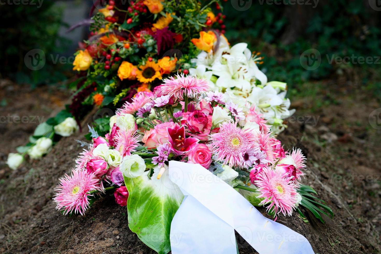 arranjo de flores funeral colorido em uma sepultura após o funeral foto