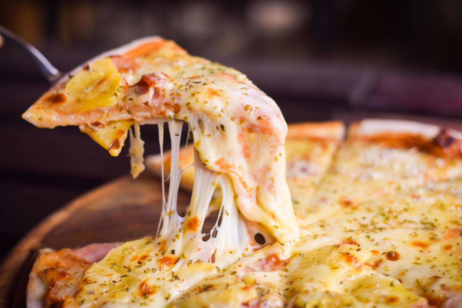 pizza de queijo havaiano na mesa de madeira. conceito de comida caseira foto