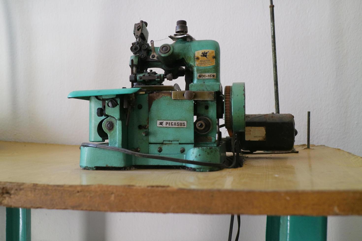 uma máquina overlock verde para costurar roupas é colocada sobre a mesa foto