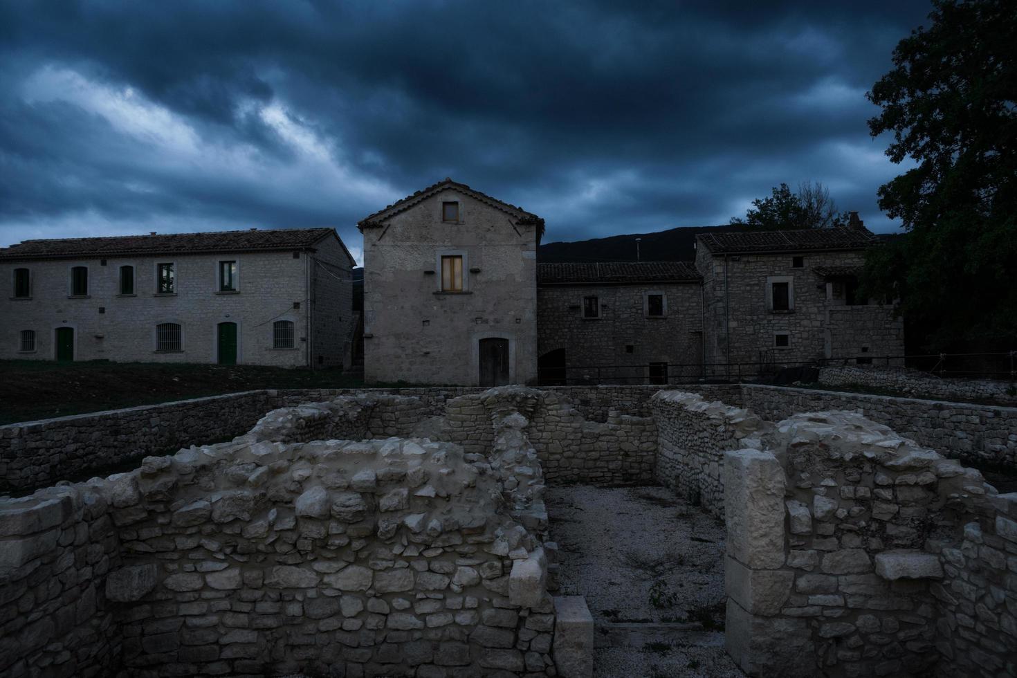 ruínas antigas no sítio arqueológico de uma antiga cidade romana na Itália central, arquitetura da velha europa abandonada em uma noite escura e sombria com um céu nublado foto